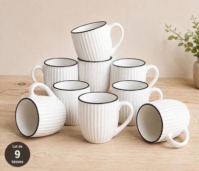 six tasses à café blanches à bord noir posées sur une table en bois
