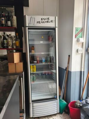 a refrigerator that is sitting in the corner of a kitchen
