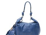sac à main en cuir bleu orné de pompons sur fond blanc