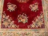 a red area rug with floral designs on it