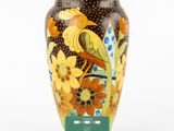 a vase that has a bird on it and flowers on it