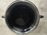 a cup of black liquid sitting on a wooden table