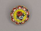 an image of a yellow and red broochle with flowers on it