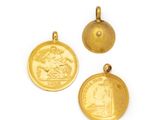three gold coin pendants on a white background