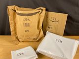 deux sacs de nourriture posés sur une table en bois à côté d'un sac de nourriture