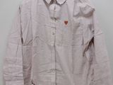 shirt hanging on a hanger on a white wall with a heart on it