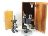 two microscopes and a box on a white surface