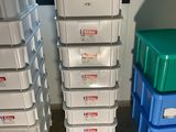 many plastic boxes stacked on top of each other in a room