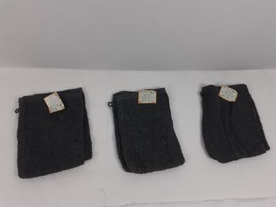 trois paires de chaussettes noires posées sur une surface blanche