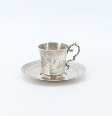 an antique silver cup and saucer on a saucer on a white background