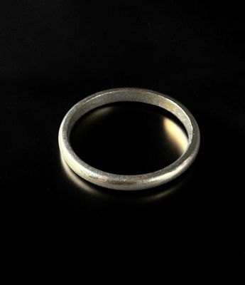 gros plan d'une bague en argent sur une surface noire