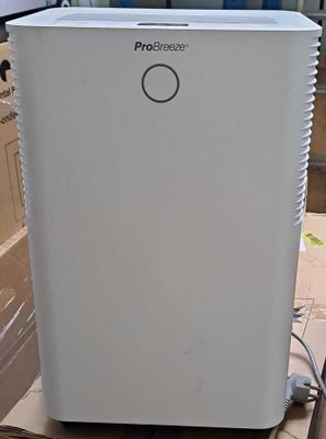 a white air conditioner sitting on top of a cardboard box