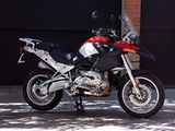 a red and black motorcycle parked in front of a building
