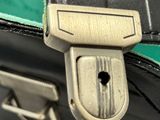 a close up of a black suitcase with a green handle