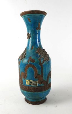 a blue vase with a design on it sitting on a table