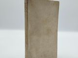 an old book sitting on top of a white surface