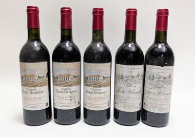 quatre bouteilles de vin sont alignées sur une surface blanche