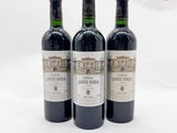 trois bouteilles de vin rouge posées sur une table blanche