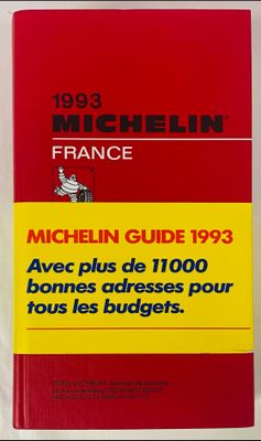un livre rouge posé sur une table blanche, à côté d'un livre rouge et jaune