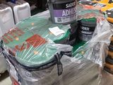 Des cartons de peinture et d'autres articles sont empilés sur une étagère dans un entrepôt