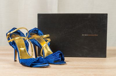 the blue and gold high heeled shoes are next to a black box