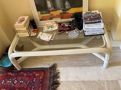 a glass coffee table with magazines on it in a room