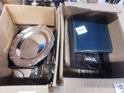 une boîte contenant une assiette en argent et une assiette en argent à l'intérieur