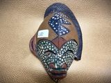 a mask on the wall with a tag on it