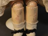 a close up of a doll wearing a dress and shoes