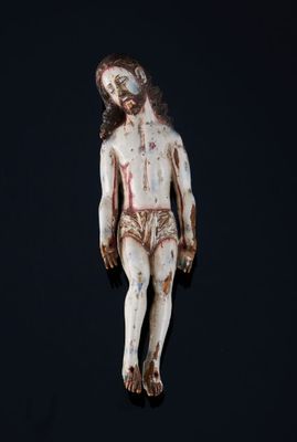 une image représentant une statue en bois d'un homme avec une croix sur la poitrine