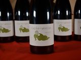six bottles of wine are lined up on a red table
