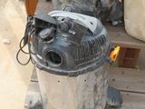 a dust collector sitting on a pallet next to a trash can