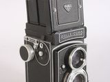a black and silver camera sitting on a white surface
