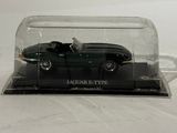 a black car in a glass case on a white surface