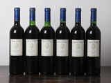 six bouteilles de vin sont alignées sur une table en bois