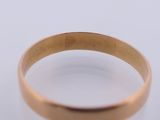 a close up of a gold ring on a white surface