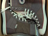 des chaussures Converse dans une boîte posée sur une table recouverte d'une nappe blanche