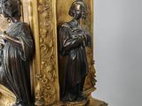 a statue of a woman and a man sitting on a clock