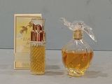 a small bottle of perfume next to a box of perfume