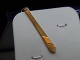 a gold tie bar sitting on top of a white table