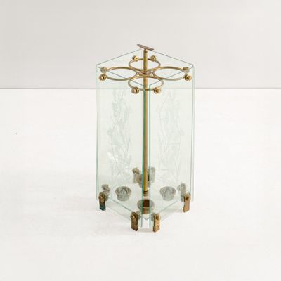 une table en verre avec un piètement en métal doré et un plateau en verre