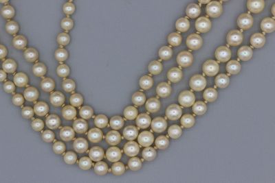 un gros plan d'un collier orné de perles sur un fond gris