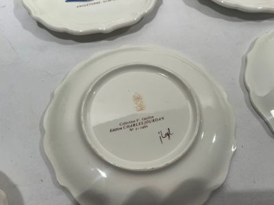 four plates with different designs on them sitting on a table
