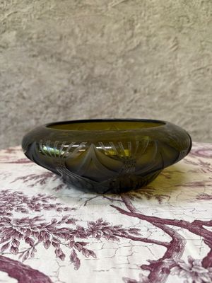 a green glass bowl sitting on a table with a red and white table cloth
