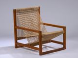 La chaise est en bois et possède une assise tressée.