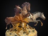 une statue représentant trois chevaux au galop sur une colline