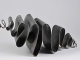 sculpture made of black metal spirals on a white surface