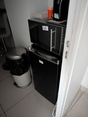 a small refrigerator and a microwave in a small room