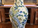 un vase posé sur une table devant un tableau