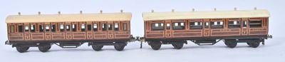 deux petits trains miniatures posés côte à côte sur une surface blanche